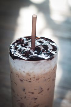 Glass of iced coffee on wooden table, stock photo