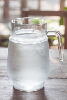 Jar of cold water on wooden table, stock photo