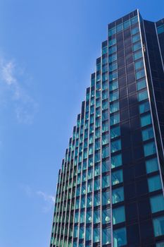 Detail of a modern skyscraper, which is reflecting the bright blue summer sky. Downtown Detroit, Michigan, USA