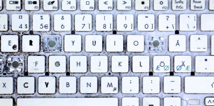 A close view of some keys on a dirty, yellowed keyboard.
