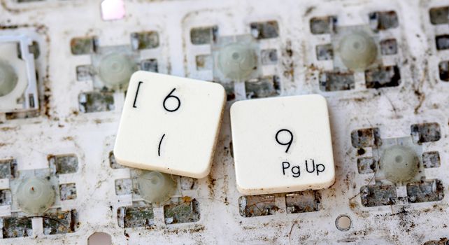 A close view of some keys on a dirty, yellowed keyboard.numbers 6 and 9