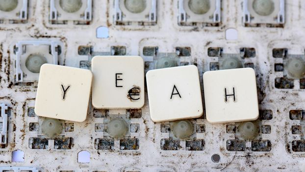 A close view of some keys on a dirty, yellowed keyboard.text yeah