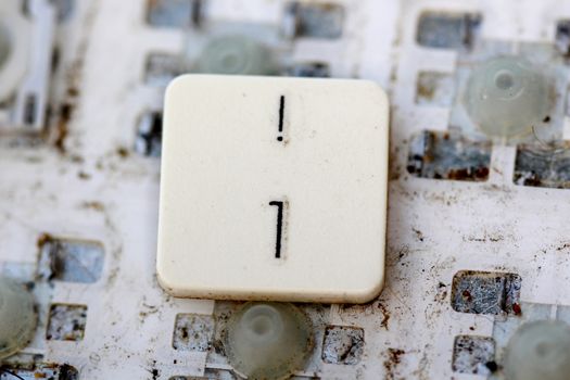 A close view of some keys on a dirty, yellowed keyboard.number one