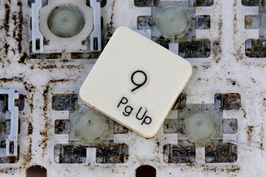 A close view of some keys on a dirty, yellowed keyboard.number 9