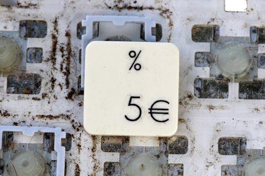A close view of some keys on a dirty, yellowed keyboard. number 5 and euro sign