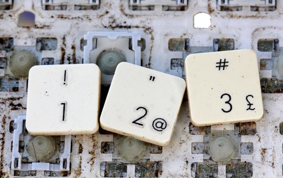 A close view of some keys on a dirty, yellowed keyboard. number 123