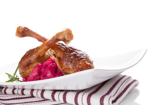 Delicious roast duck with red cabbage, traditional festive eating. Grilled drumsticks with rosemary and red cabbage.
