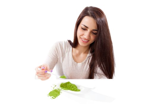 Detox. Beautiful girl with green ground powder on spoon isolated on white. Spirulina, chlorella and wheatgrass. Healthy lifestyle, detox.
