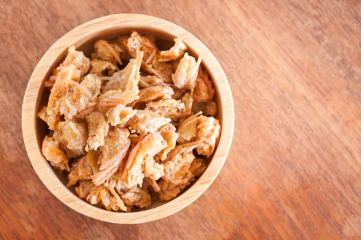 Fried shrimp chins snack in wooden bowl, stock photo