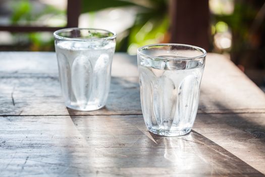 Glasses of cold water on wooden table, stock photo