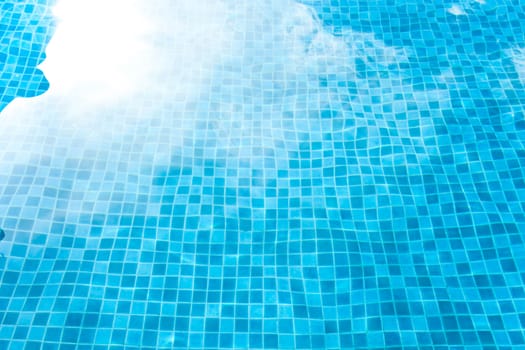 Blue tiled swimming pool background. View from eye.