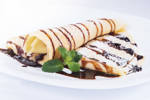 Pancakes with chocolate sauce and mint  on a plate