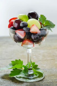 Fresh forest berries and melon  in a glass on a white background isolated