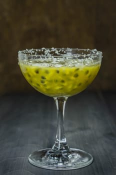 Fresh passion fruit juice in glass with passion fruits over wooden background , still life