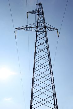 High voltage power pylons against blue sky.