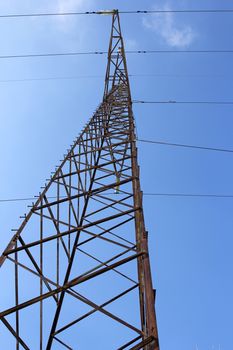 High voltage power pylons against blue sky.