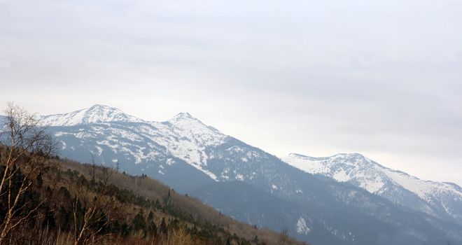 Mountain ridges covered with snow and overcast sky.