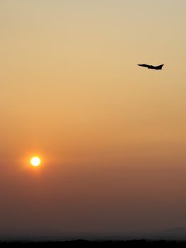 Silhouette airplane in the sky at sunrise