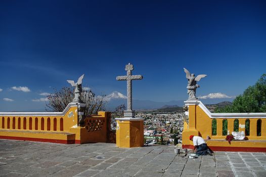 Puebla, Mexico - January 20, 2010: Church of Our Lady of Remedies on top of the Cholula Pyramid in Puebla, Mexico. Aerial view of the city and Popocatepetl volcano