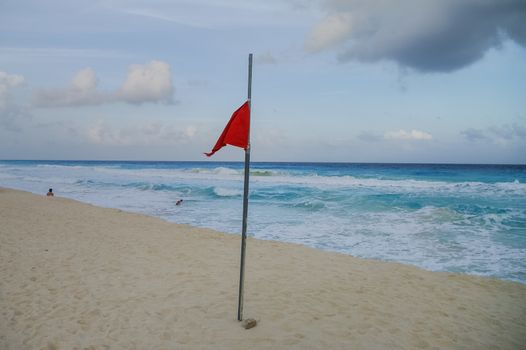 Stiorm flag on the beac. Waves on the coast of the Caribbean Sea, Mexico. Riviera Maya