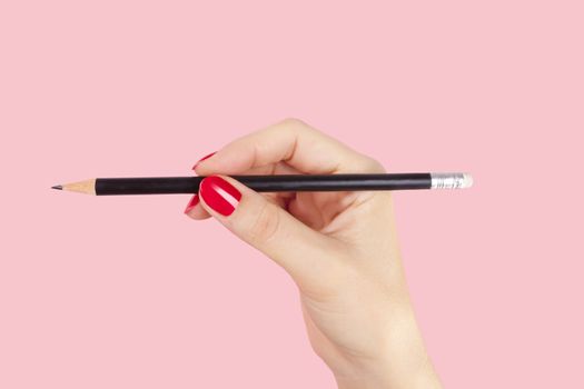 Creative idea business. Art director, Advertising business. Female hand holding pencil against pink background. 