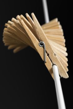 Wooden clothespins in fan shape to a white thread
