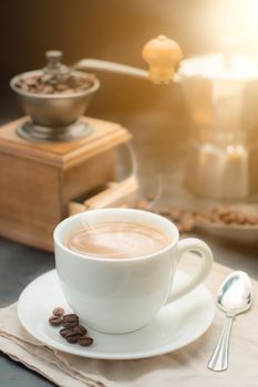 coffee cup and vintage coffee mill with coffee maker pot on old wooden table