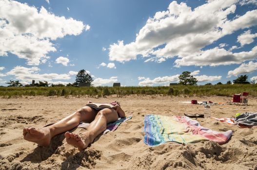 woman in bikini reading a book on a beach