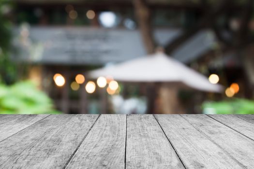 Black and white wooden table top with cafe blurred abstract background