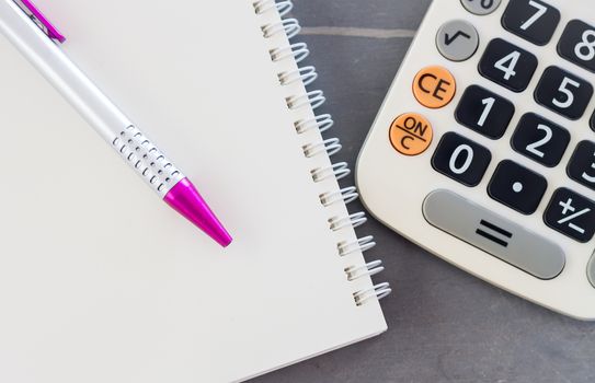 Calculator, notepad and pen on grey background, stock photo