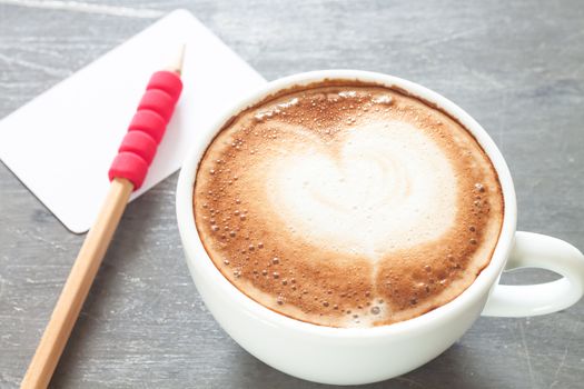 Coffee cup with name card on grey background, stock photo
