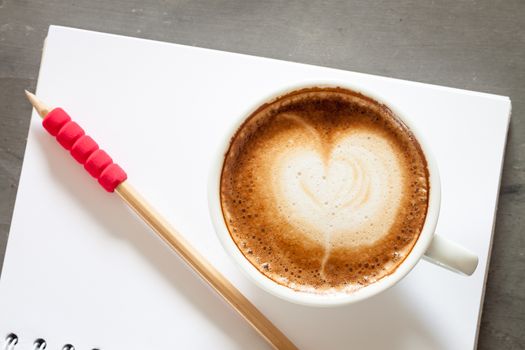 Coffee cup with notepad on grey background, stock photo