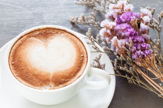 Coffee cup with beautiful violet flower, stock photo