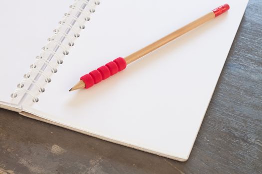 Blank notebook with pencil on grey background, business concept