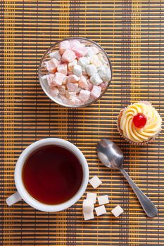 Tea, fresh cherry muffin, colorful delight and sugar