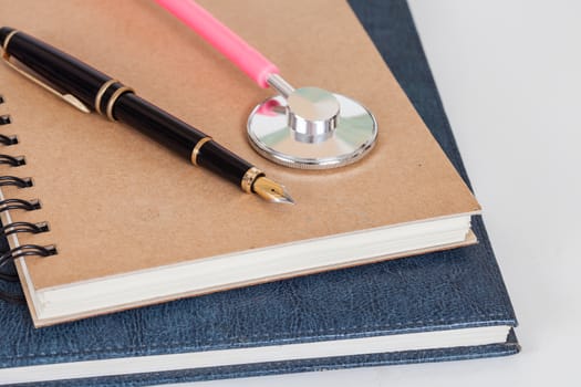 Diary with  pen and stethoscope isolated on white background