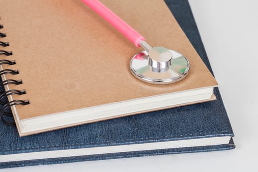 Diary  and stethoscope isolated on white background