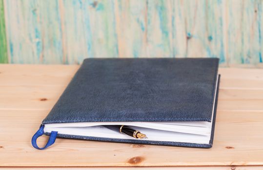 selective focus of the  pen on opened lined diary book , 
extremely shallow DOF