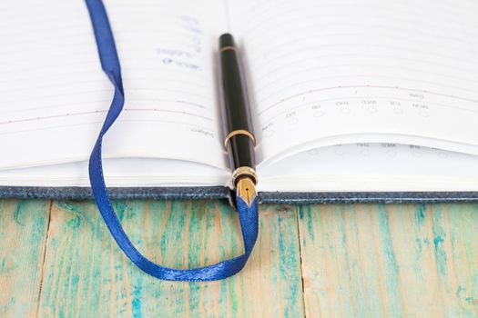 selective focus of the  pen on opened lined diary book , 
extremely shallow DOF
