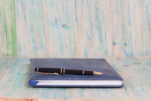 Diary with  pen  on wood background