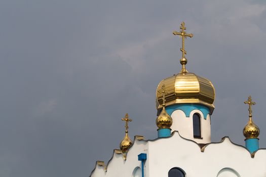 Partly finished construction of an orthodox church in the city Holic, Slovakia. Golden shiny domes and three crosses.