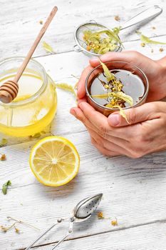 Cup the hands with healing tea from dried Linden flower and honey