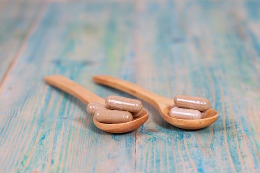 Capsules of herbs on spoon. healthy eating for healthy living.
