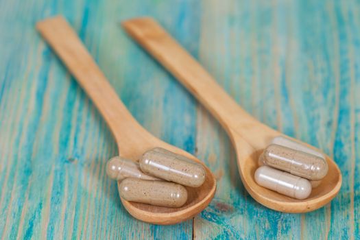 Capsules of herbs on spoon. healthy eating for healthy living.
