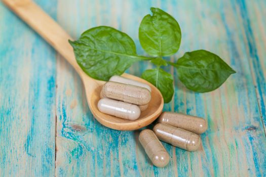 Capsules of herbs on spoon. healthy eating for healthy living.