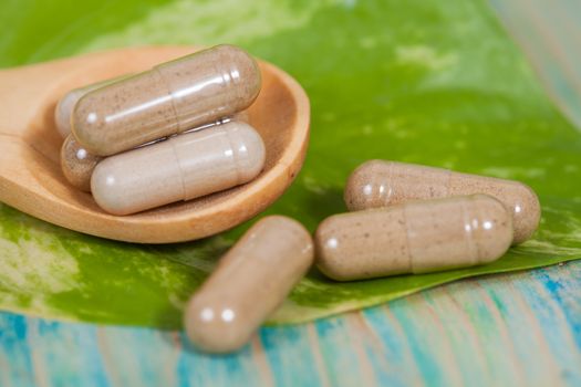 Capsules of herbs on spoon. healthy eating for healthy living.