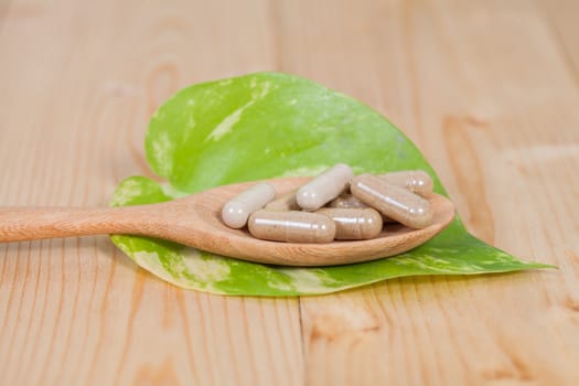 Capsules of herbs on spoon. healthy eating for healthy 
living.