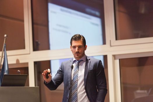 Speaker giving talk on podium at Business Conference. Entrepreneurship club. Horizontal composition.