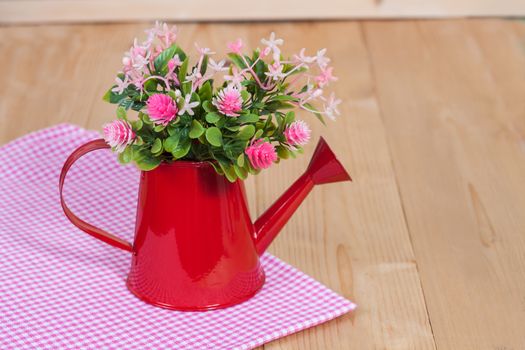 flowers in red watering on wood