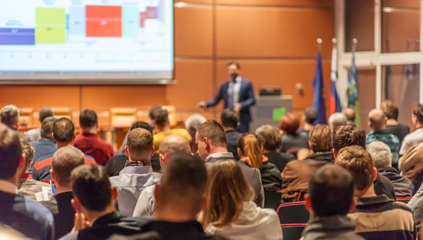 Speaker giving a talk in conference hall at business event. Audience at the conference hall. Business and Entrepreneurship concept.